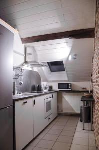 霍尔斯贝克Hageland Vakantieverblijf的厨房配有白色橱柜和炉灶烤箱。