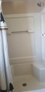 格兰德莱克Columbine Cabins的带浴缸和淋浴帘的浴室