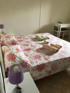 瓦雷多利亚Il Ginepro的一间卧室配有一张带粉红色花卉床罩的床。