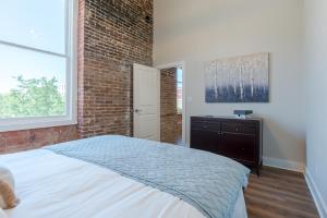 加尔维斯敦Meilleur的一间卧室设有一张床和砖墙