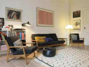 哥本哈根ApartmentInCopenhagen Apartment 1282的客厅配有沙发和两把椅子