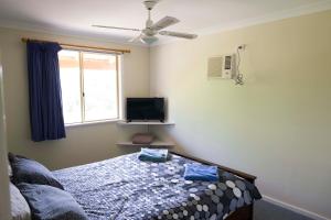 兰斯林兰斯林旅舍的一间卧室设有一张床、一台电视和一个窗口。
