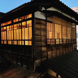 桐生市Okiya Guest House & Tapas Bar的木制建筑,在甲板上设有窗户