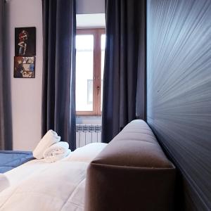 阿格里真托索奈多若酒店的一间卧室配有一张带蓝色窗帘的床和一扇窗户