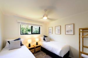 圣海伦斯Georges Bay Apartments的配有两盏灯和一扇窗户的客房内的两张床