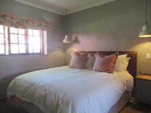 德尔斯特鲁姆Critchley Hackle Dullstroom Leisure的一间卧室配有带白色床单和枕头的床。