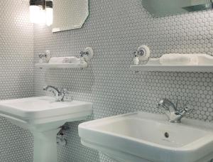 巴黎巴舒蒙特酒店的白色的浴室设有两个盥洗盆和镜子