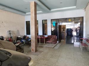 当格浪Hotel Alifah 2的一间设有摩托车和桌椅的房间