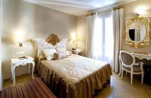 塞维利亚塞维利亚阿德里亚诺精品酒店的一间卧室配有一张大床和镜子