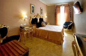 塞维利亚塞维利亚阿德里亚诺精品酒店的一间卧室配有一张特大号床和金色家具