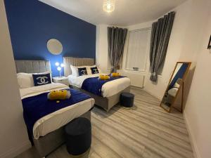 MossendHLA Holytown的一间卧室设有两张床和蓝色的墙壁