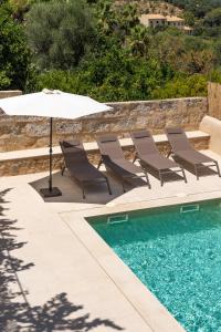 坎帕内特Cas Suis 7的一组椅子和一把遮阳伞,位于游泳池旁
