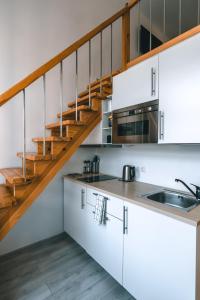 考纳斯Brother House Kaunas的一间厨房,配有白色橱柜和楼梯