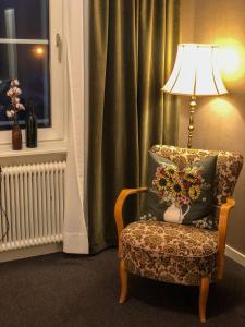 马隆Villa Bergli的椅子旁的灯和枕头