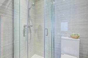 伦敦公园大道肯斯威公园酒店的浴室设有玻璃淋浴间和卫生间