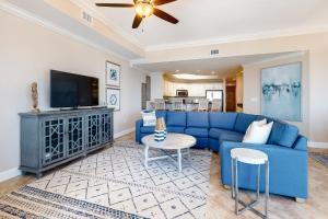 奥兰治比奇Phoenix West II #609的客厅配有蓝色的沙发和电视