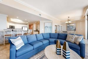 奥兰治比奇Phoenix West II #609的客厅配有一张蓝色的沙发,配有一张桌子
