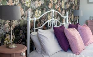 阿尔弗斯顿太阳旅馆的卧室内的一张带紫色和白色枕头的床