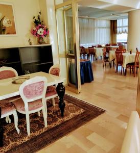 里米尼城堡酒店的一间带桌椅的房间和一间用餐室