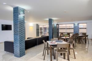 贝尼多姆Aparthotel BCL Levante Club的用餐室配有桌椅和沙发