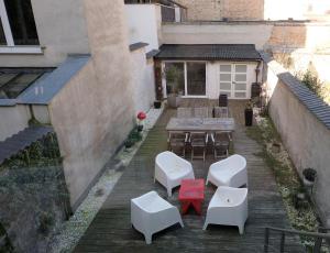 奥斯坦德Villa Les Paquerettes的户外庭院配有桌子和白色椅子