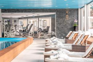 达沃斯岳罗普酒店的一个带椅子的健身房和一个游泳池