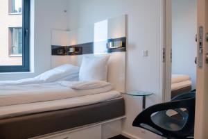 哥本哈根哥本哈根沃克阿普 - 伯格嘉德酒店的一间卧室配有一张带镜子和椅子的床