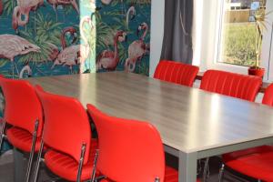 泽皮恩约维尔弗鲁特霍夫酒店的一间会议室,配有桌子和红色椅子