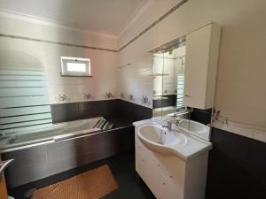 Carvalhalcasa das Termas do Carvalhal的浴室配有盥洗盆、镜子和浴缸