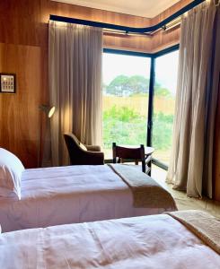 何塞伊格纳西奥Rizoma的酒店客房设有两张床和大窗户。
