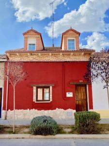 鲁埃达La Parada de Jimena-Casa rústica rodeada de bodegas en Rueda的一座红色的建筑,上面有一座塔