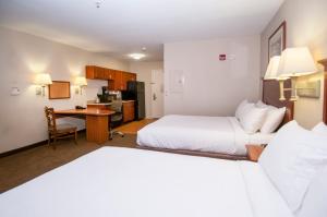 弗洛伍德烛木套房酒店客房内的一张或多张床位