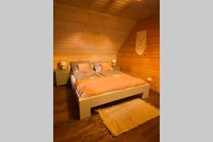 下乌斯奇基Znam Ten Widok - Bieszczady的木制客房内的一间卧室,配有一张床