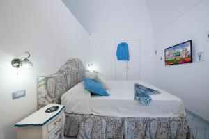 波西塔诺Maison Don Rafe'的一间小卧室,配有一张带椅子的床