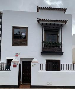 拉拉古纳guajara-loft的白色的建筑,设有2扇窗户和阳台