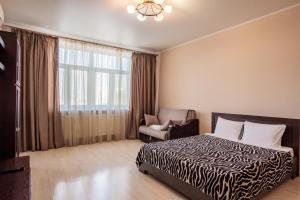 秋明Apart Hotel Abajour的卧室配有床、椅子和窗户。