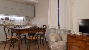 罗韦雷托Lo Scricciolo的一间带桌椅的厨房和一间带沙发的厨房