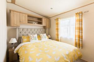 南塞尔尼Cottontail Lodge - Hot tub - Pet Friendly的一间卧室配有一张带黄色棉被的床和窗户