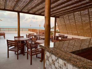 纳塔尔Swell Praia Hotel的海滩上带桌椅的餐厅