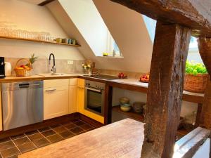 布兰肯海姆Burg Maisonette im Posthalterhof mit Sauna的阁楼厨房设有黄色橱柜和水槽