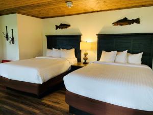 奎诺尔特奎纳尔特湖山林小屋的两张位于酒店客房的床,配有两张sidx sidx单人床
