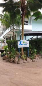 拉迪格岛拉迪格自助公寓酒店的棕榈树和建筑物前的标志