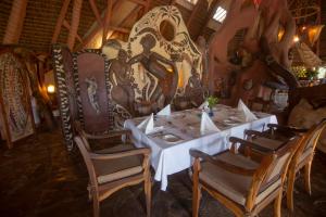 奈瓦沙Chui Lodge的用餐室配有桌椅和壁画