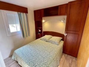 MarignyJura mobile home的一间小卧室,配有床和窗户