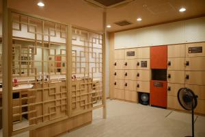 神户Dormy Inn Kobe Motomachi Natural Hot Springs的带储物柜的客房和带风扇的客房。