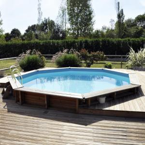 布雷叙尔Cottage du garlai的甲板上的大型游泳池,周围摆放着椅子