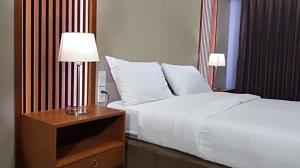 曼谷Room58的一张位于酒店客房的床位,配有一张白色床和床头柜