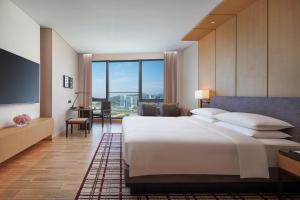 珠海横琴凯悦酒店的卧室设有一张白色大床和大窗户
