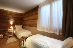 布勒伊-切尔维尼亚Petit Chalet Blanc Cervinia的一间卧室设有两张床和窗户。