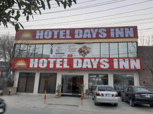 拉合尔Hotel Day In Lahore的酒店前方设有停车场